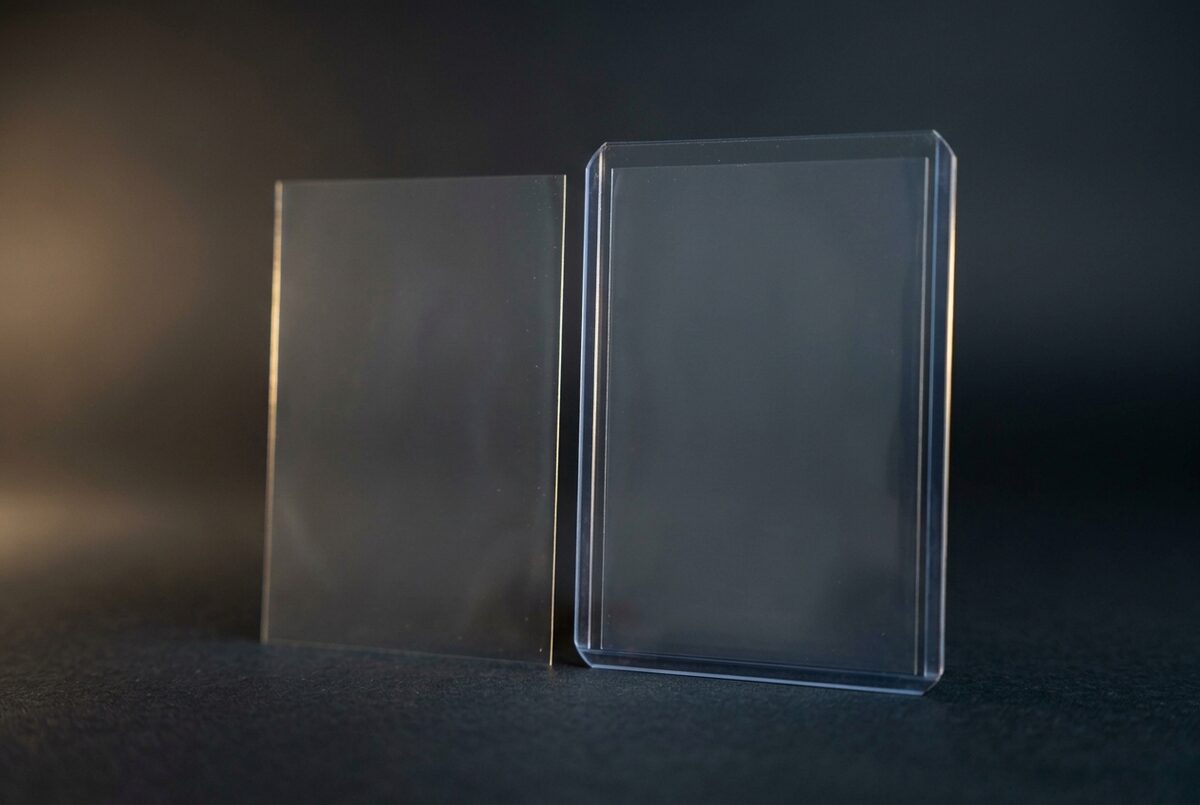 Two empty sleeves side by side, a thin inner layer and a thicker outer layer, on a dark background with a gold light accent